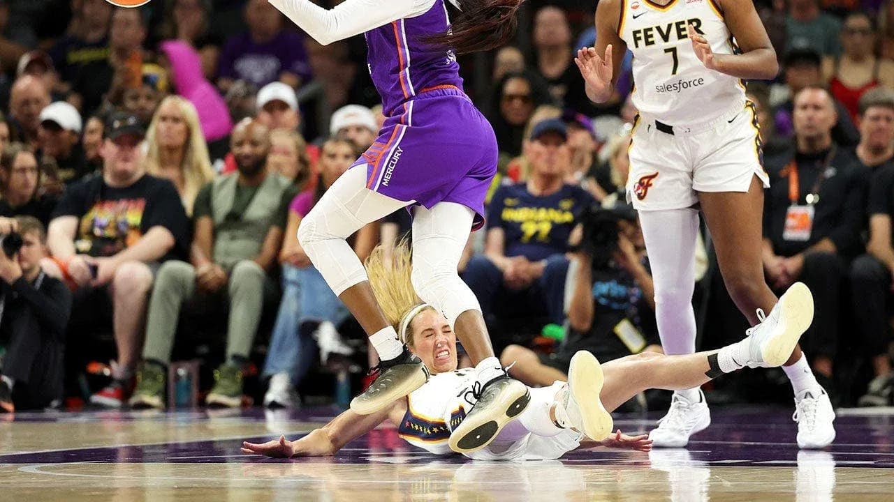 Player falling on court during basketball game action Player falling on court during basketball game action