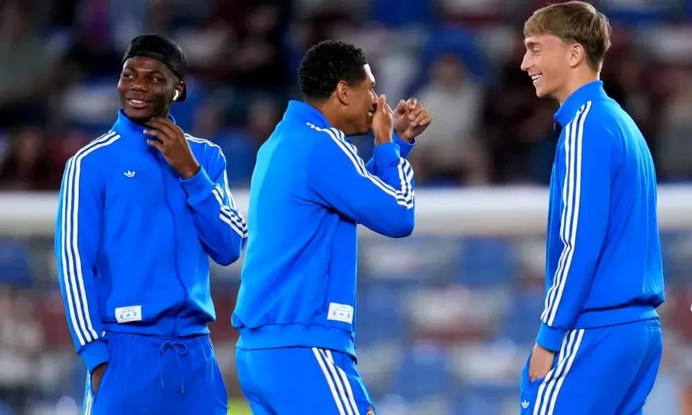 Three players in blue training gear chatting together Three players in blue training gear chatting together
