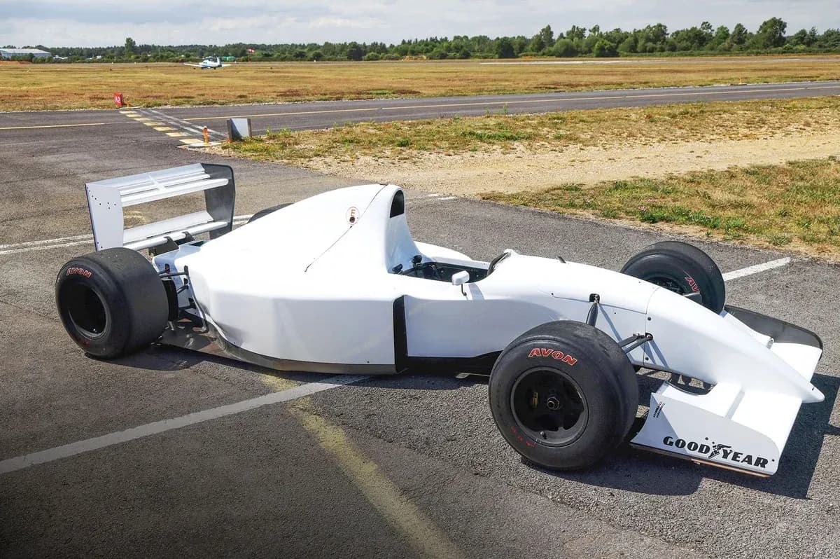 White racing car parked on an airstrip White racing car parked on an airstrip