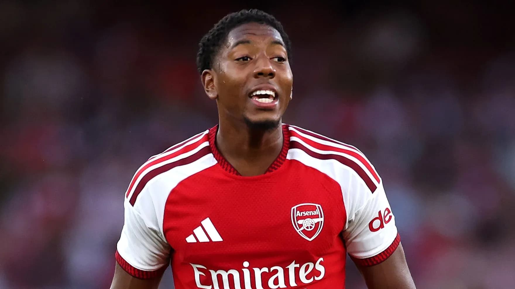 Futbolchi Arsenal formasi bilan maydonda harakatda Futbolchi Arsenal formasi bilan maydonda harakatda