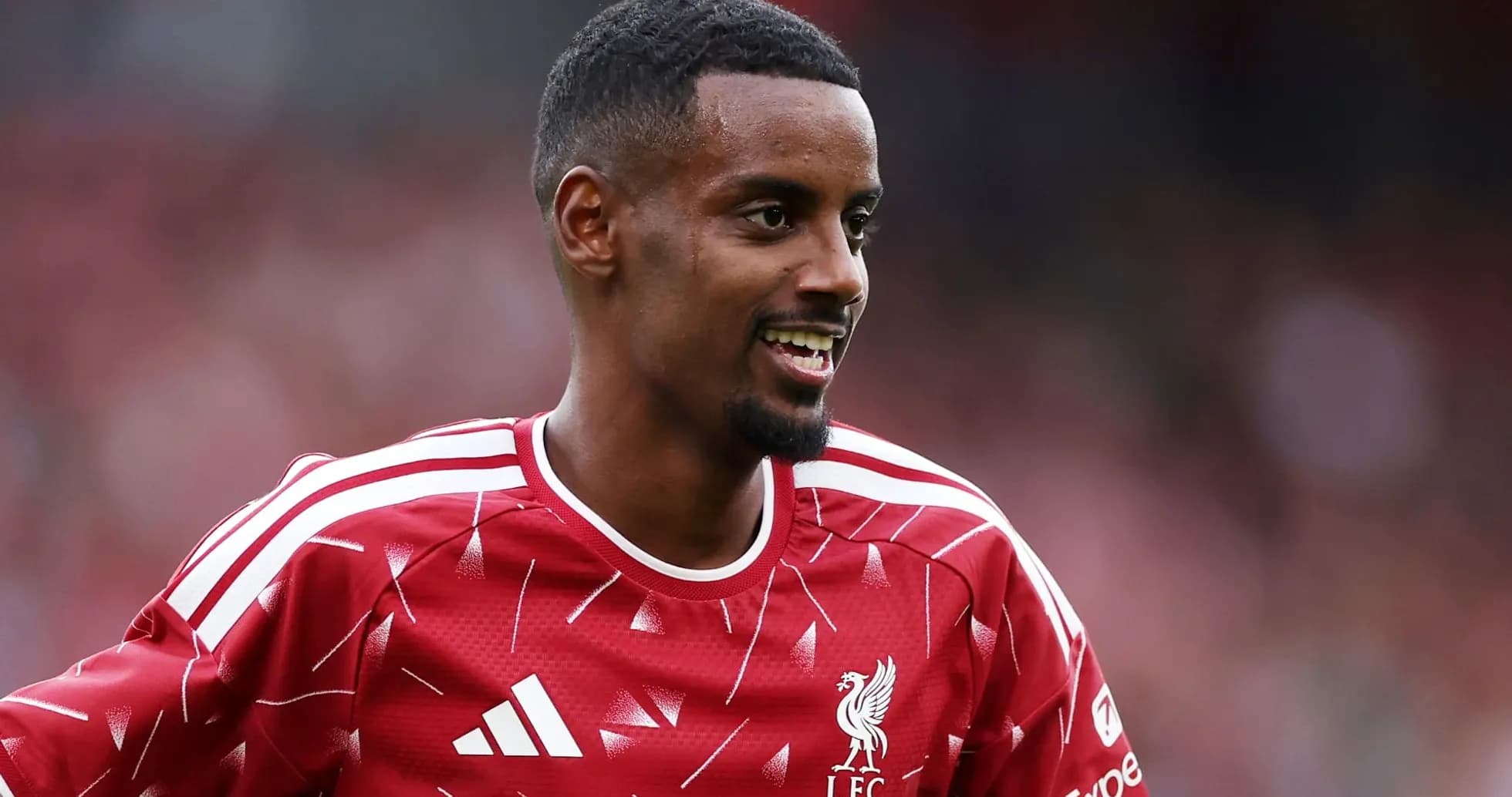 Futbolchi LFC formasi bilan maydonda kulayotgan Futbolchi LFC formasi bilan maydonda kulayotgan