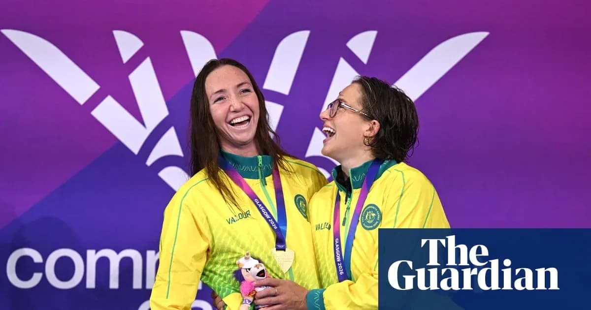 Ikki suzuvchi medal bilan sahnada tabassum qilmoqda Ikki suzuvchi medal bilan sahnada tabassum qilmoqda