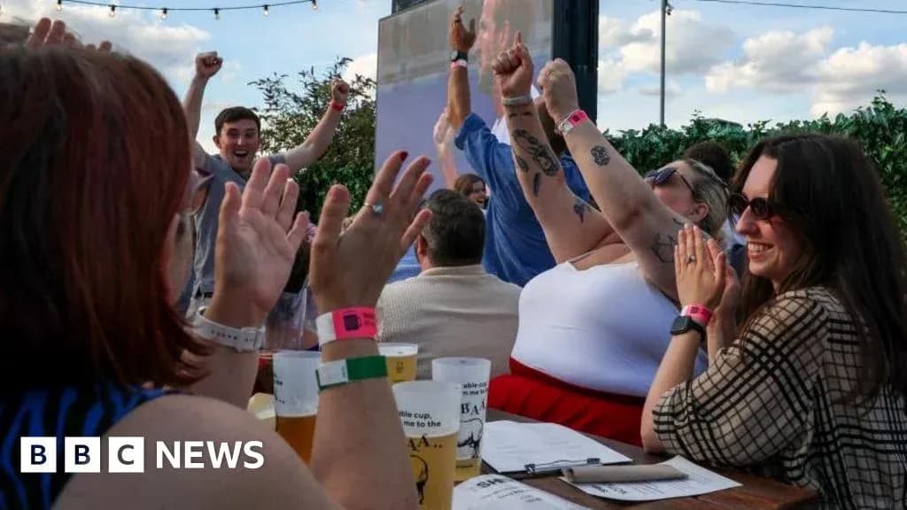 People celebrating with raised arms at outdoor venue People celebrating with raised arms at outdoor venue