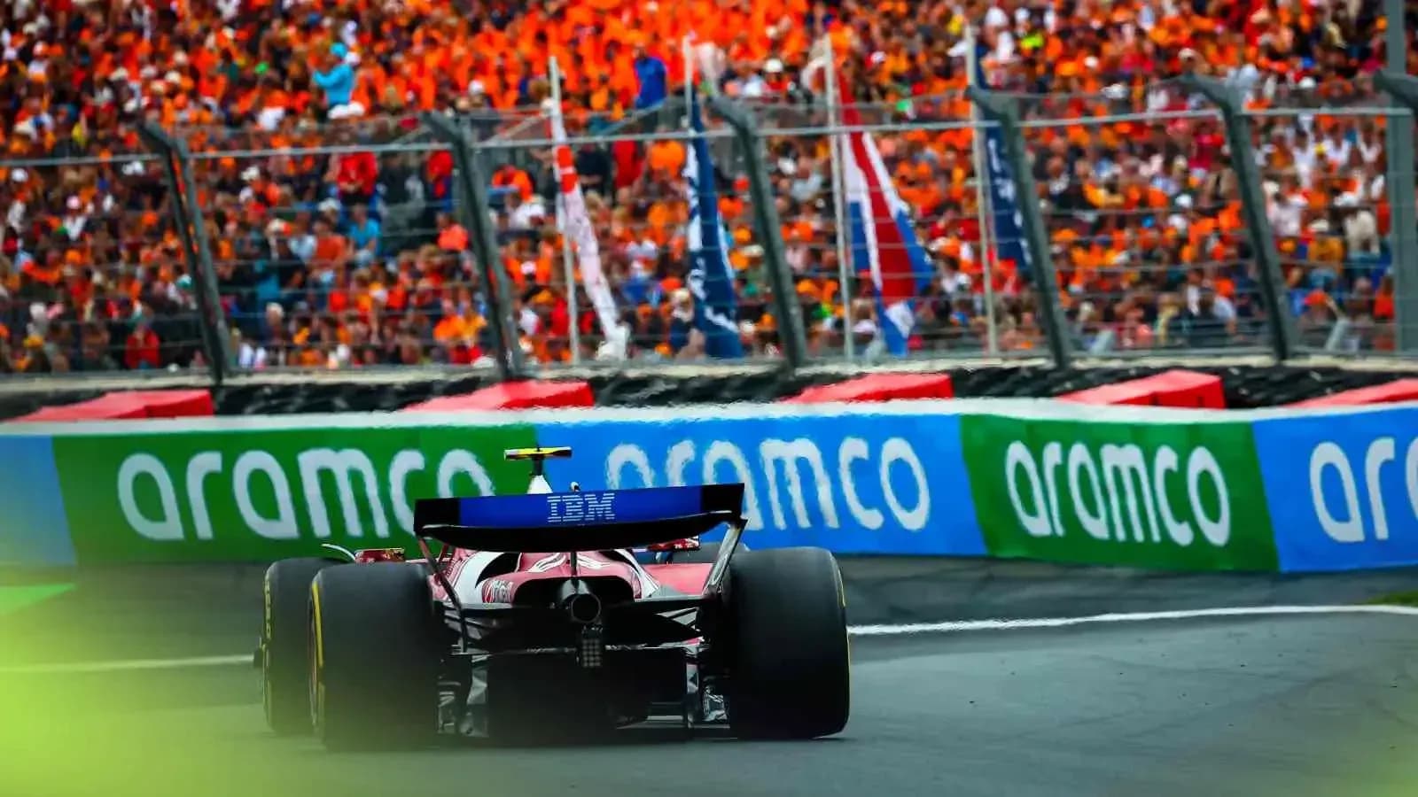 Formula 1 car racing past enthusiastic crowd Formula 1 car racing past enthusiastic crowd