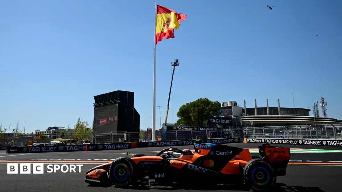 Formula 1 car racing near Spanish flag and grandstand Formula 1 car racing near Spanish flag and grandstand