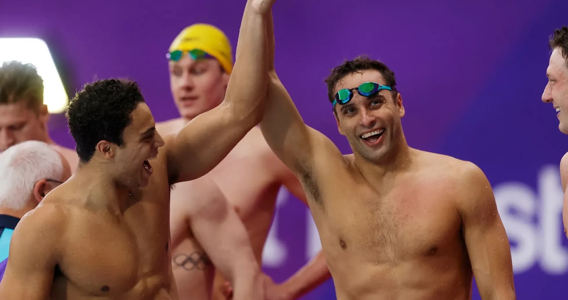 Two swimmers celebrating victory with raised arms Two swimmers celebrating victory with raised arms
