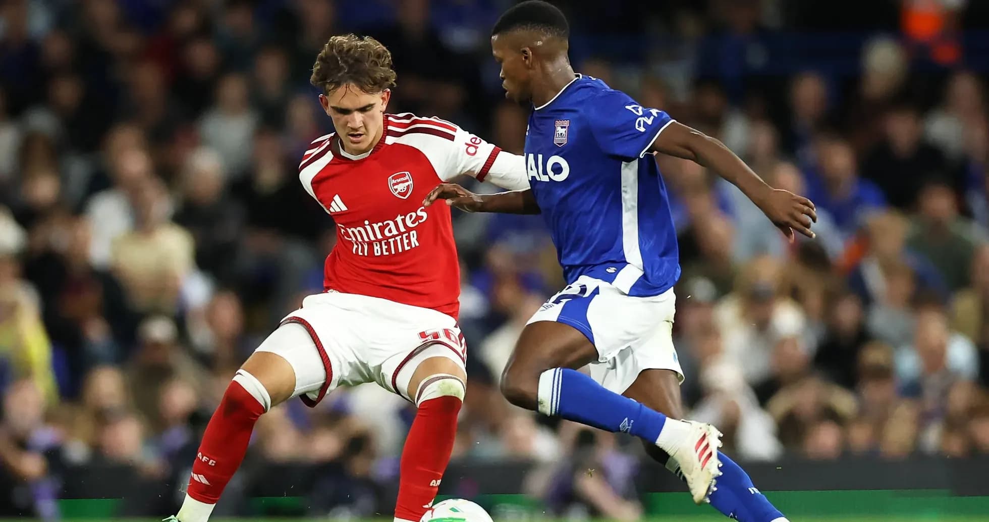 Arsenal player challenged by Ipswich Town opponent Arsenal player challenged by Ipswich Town opponent