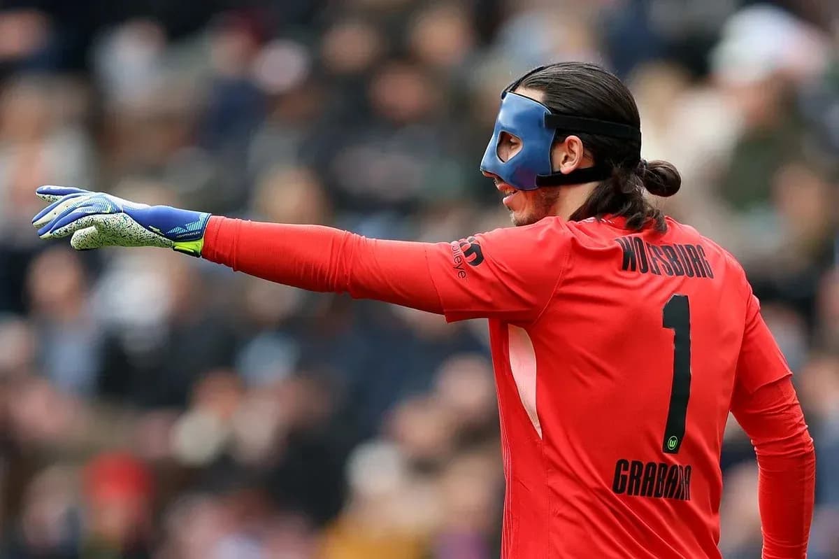 Goalkeeper in red kit signaling during match Goalkeeper in red kit signaling during match