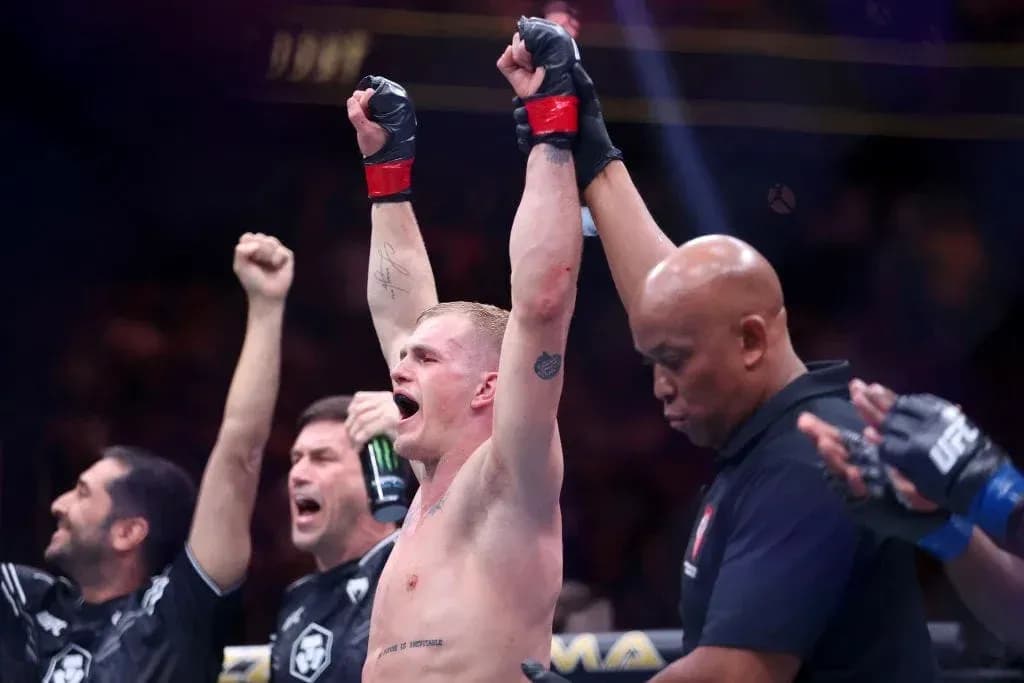 Fighter celebrating victory with raised arms in octagon Fighter celebrating victory with raised arms in octagon