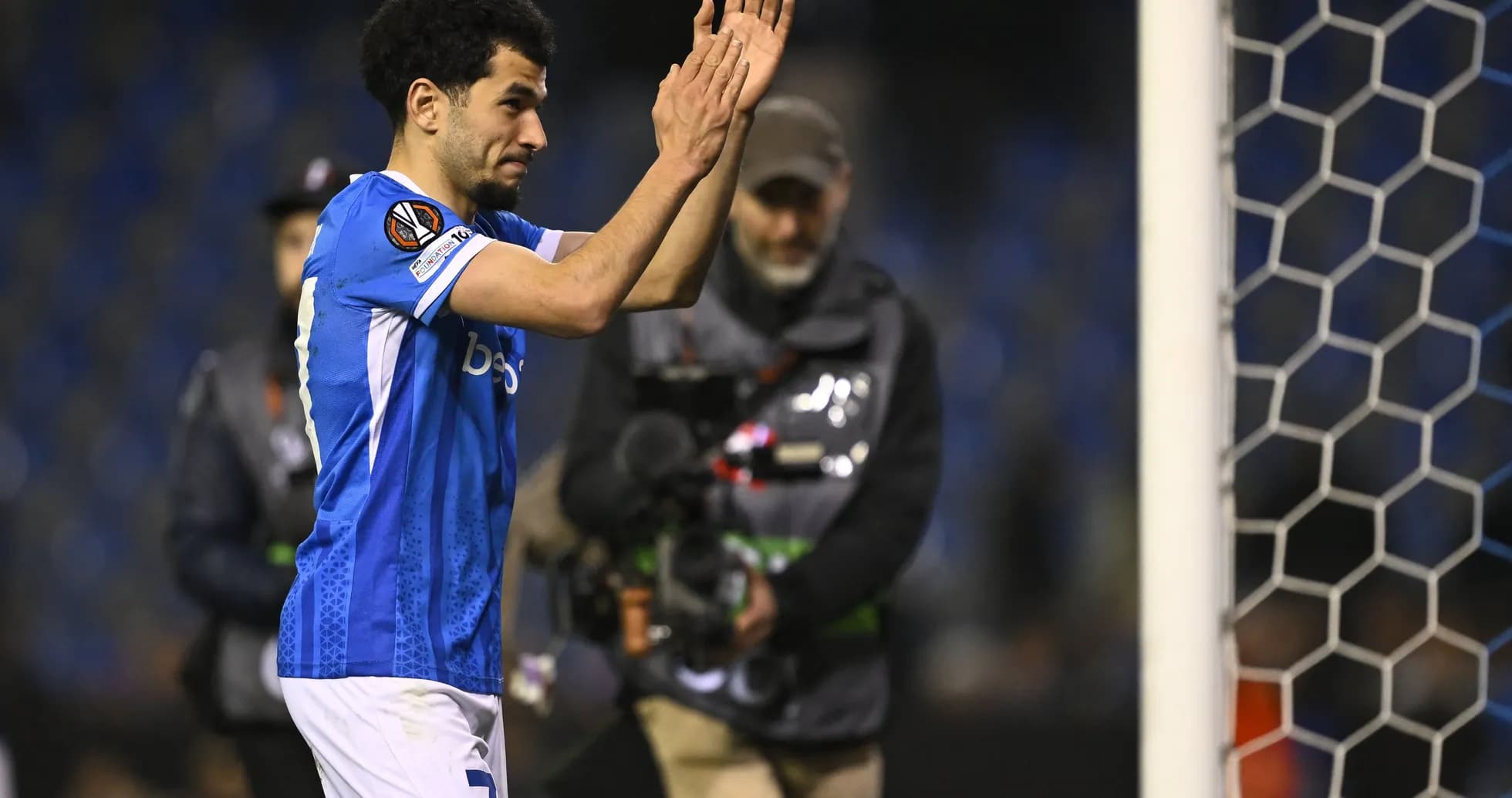Futbolchi maydonda qo'lini ko'tarib muxlislarga salom bermoqda Futbolchi maydonda qo'lini ko'tarib muxlislarga salom bermoqda