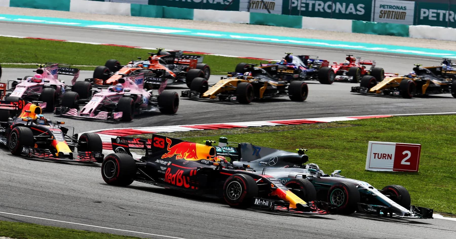 Formula 1 cars racing at Turn 2 of circuit Formula 1 cars racing at Turn 2 of circuit