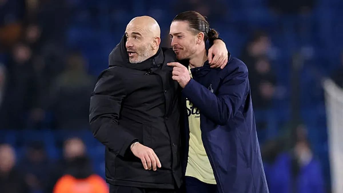 Two men embracing on football pitch after match Two men embracing on football pitch after match