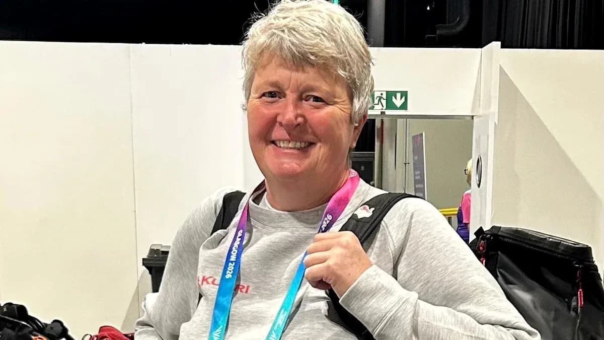 Woman smiling with a medal at an event Woman smiling with a medal at an event