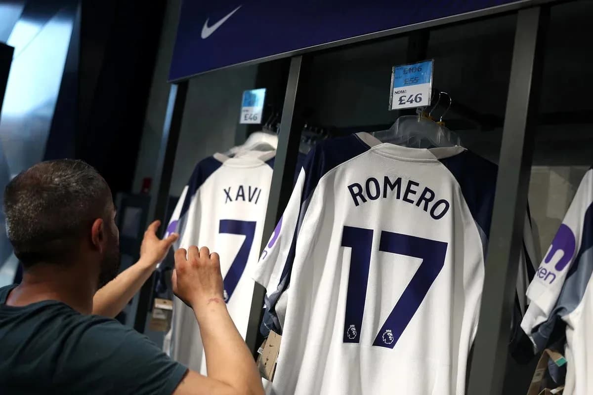 Customer examining football jerseys in store Customer examining football jerseys in store