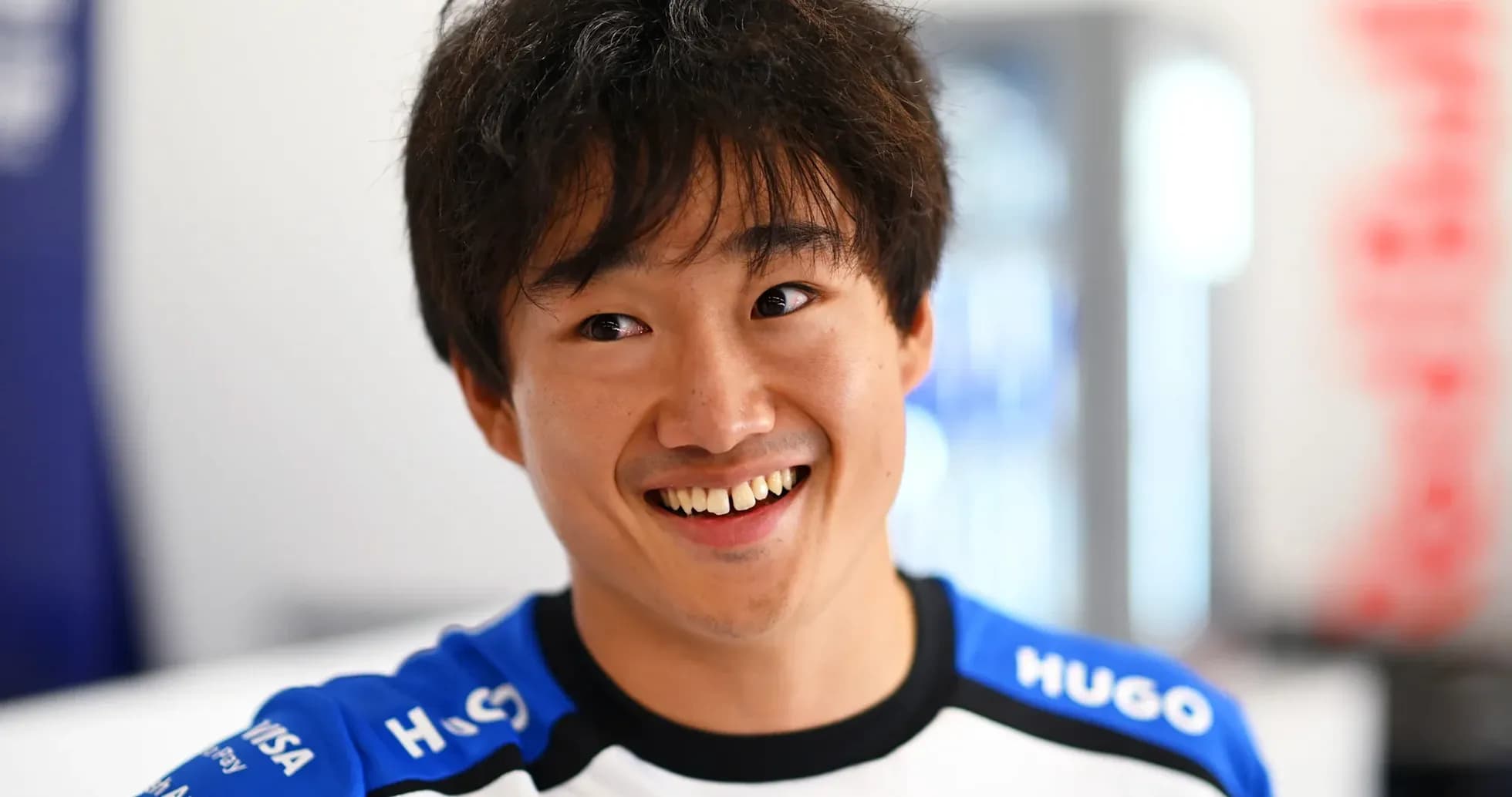 Driver smiling in team uniform during event Driver smiling in team uniform during event