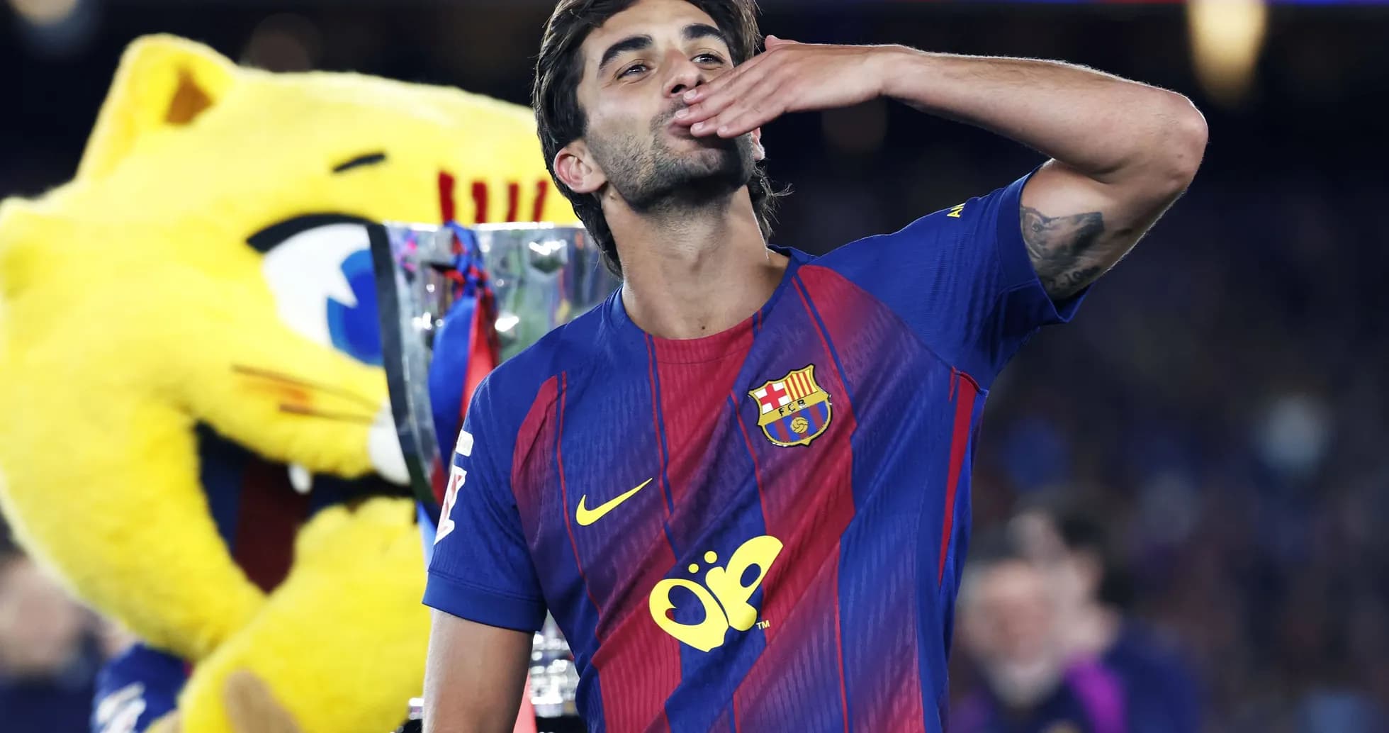 Futbolchi kubok bilan o'ralgan holda tabriklayapti Futbolchi kubok bilan o'ralgan holda tabriklayapti