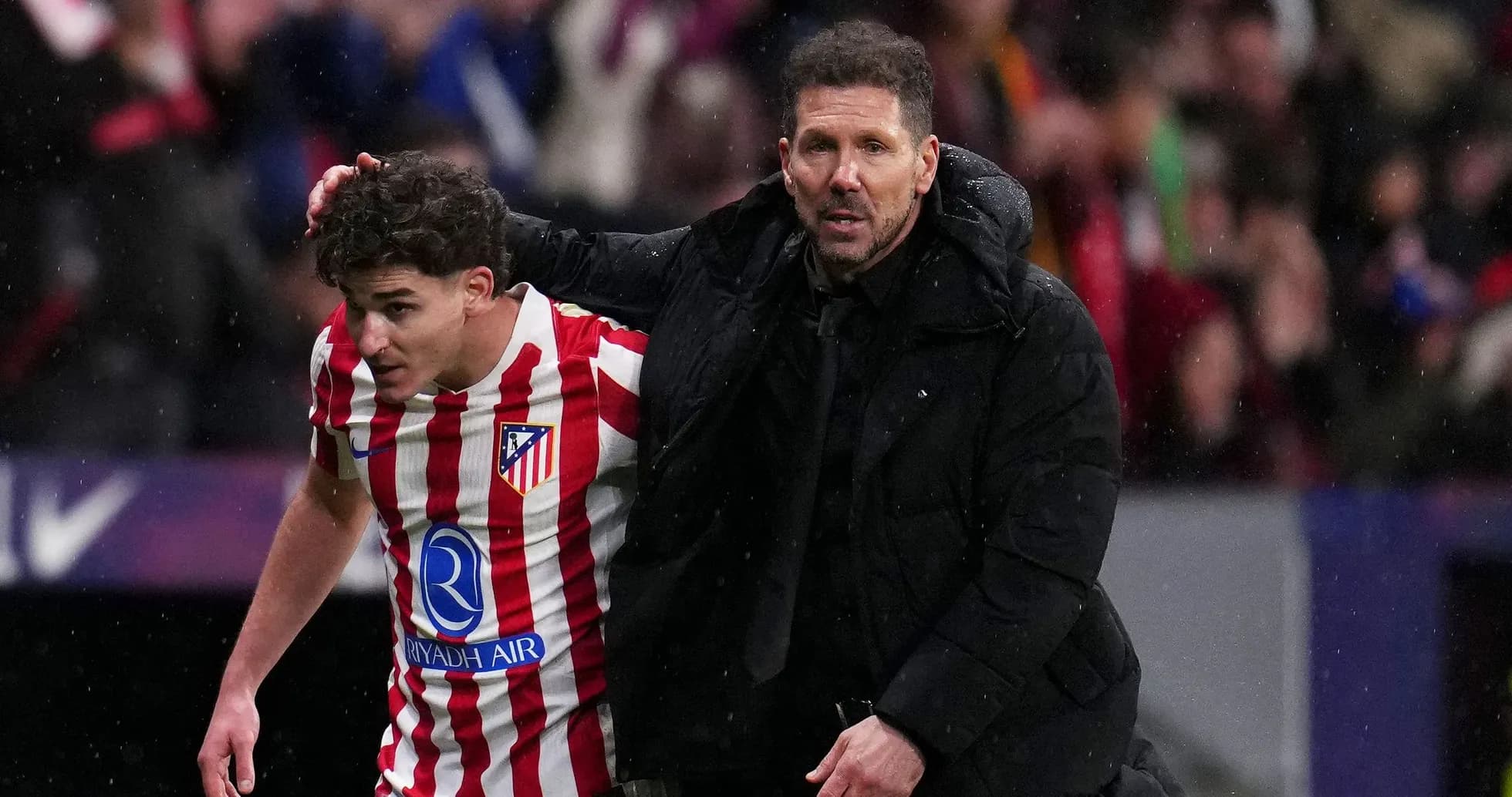 Atletiko Madrid coach assisting player off the field Atletiko Madrid coach assisting player off the field