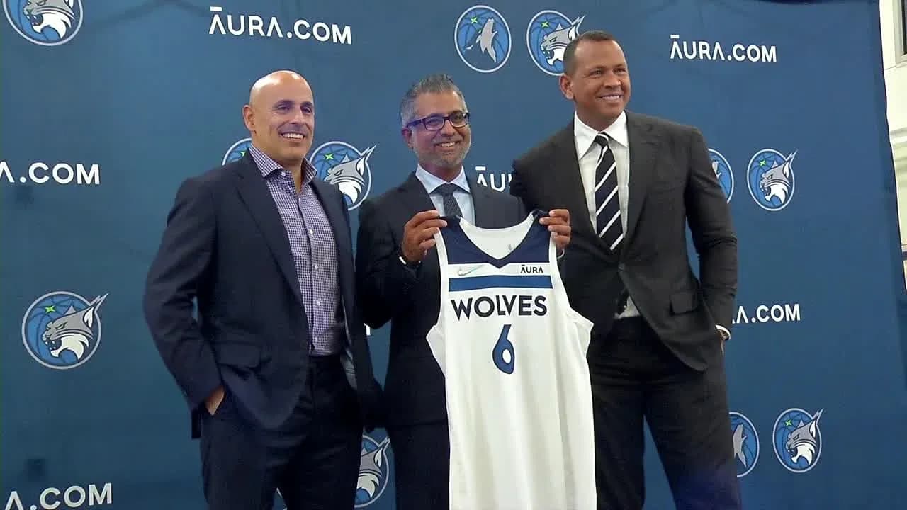 Three men presenting a Minnesota Timberwolves jersey Three men presenting a Minnesota Timberwolves jersey