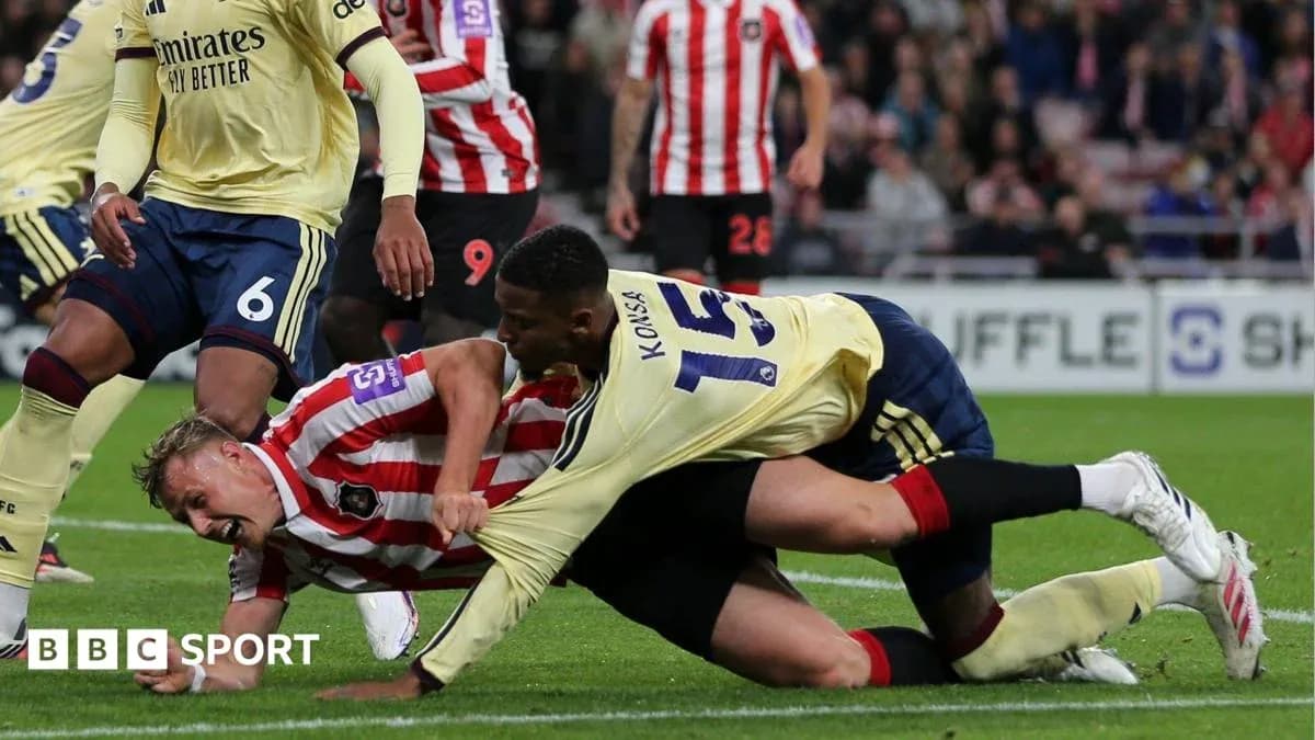 Two players competing for the ball on the ground Two players competing for the ball on the ground
