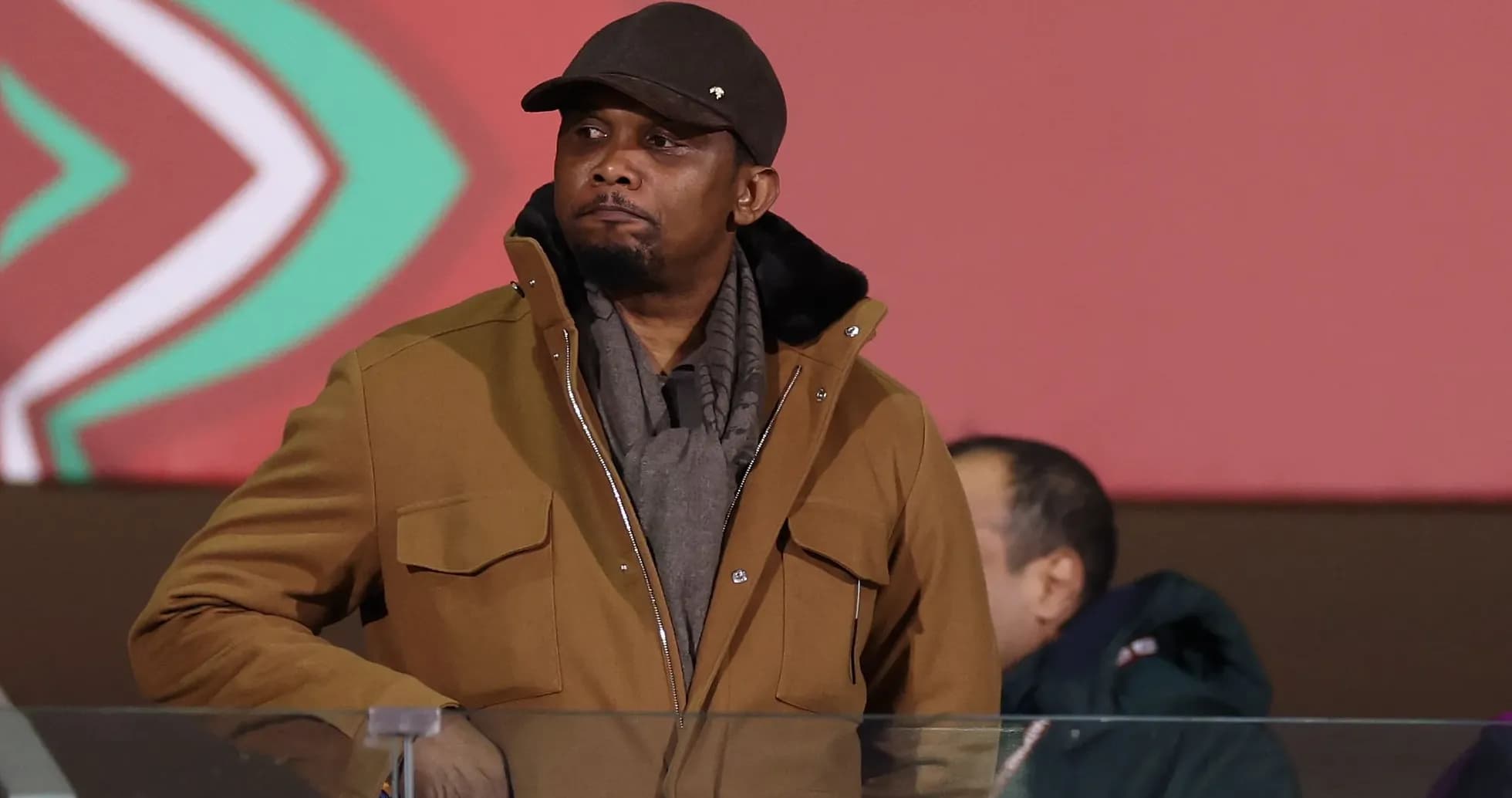 Man in brown coat at sporting event venue Man in brown coat at sporting event venue