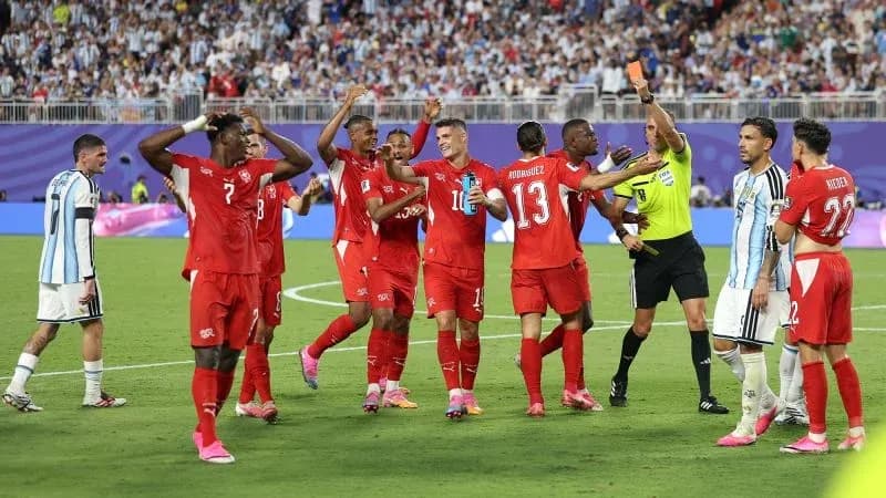 Shirtless players celebrating during match with referee Shirtless players celebrating during match with referee