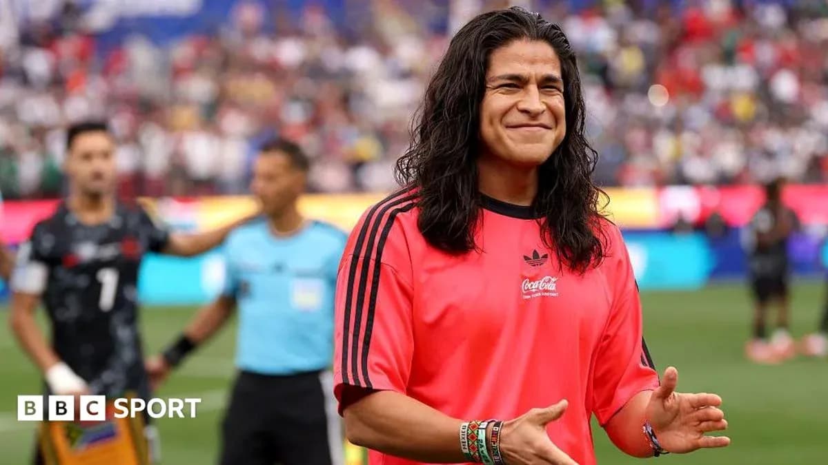 Futbolchi qizil forma kiyib, maydonda tabassum qilmoqda Futbolchi qizil forma kiyib, maydonda tabassum qilmoqda