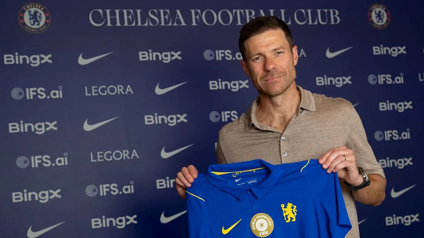 New coach holding Chelsea jersey at press conference New coach holding Chelsea jersey at press conference