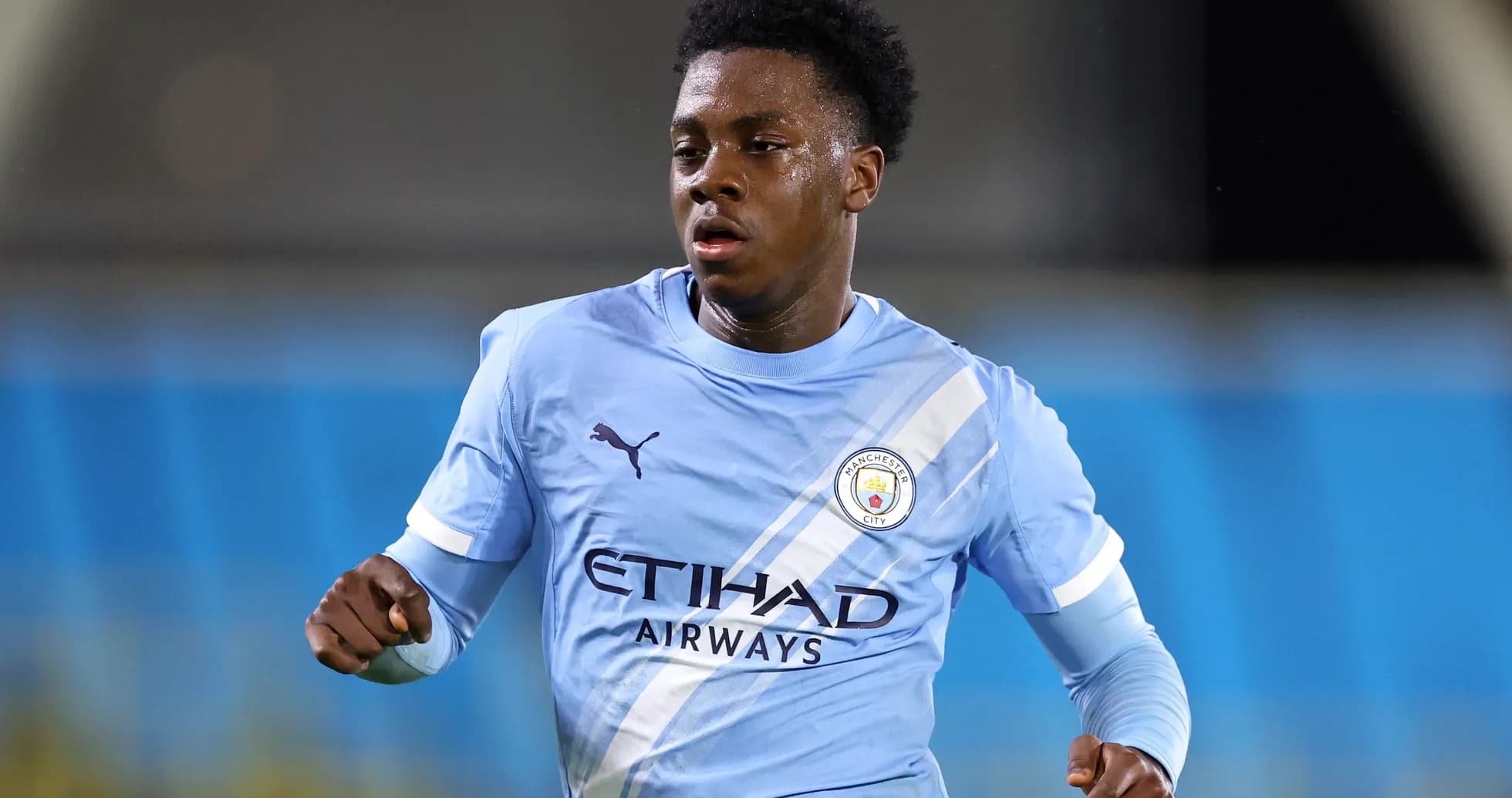 Futbolchi Manchester City formasida maydonni o'tayotgan Futbolchi Manchester City formasida maydonni o'tayotgan