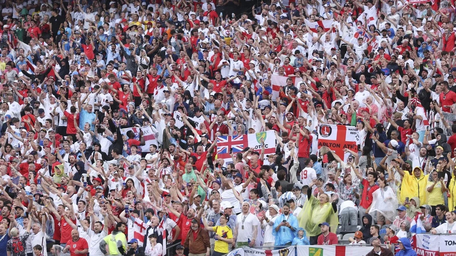 Football fans cheering in stadium wearing team colors Football fans cheering in stadium wearing team colors